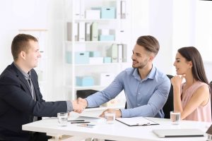 Young man shaking hands with estate agent in office