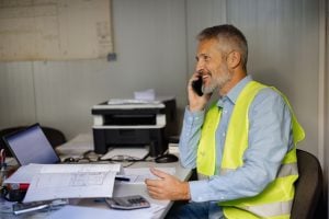 Construction Manager in Office Discussing Project Plans on Phone Call