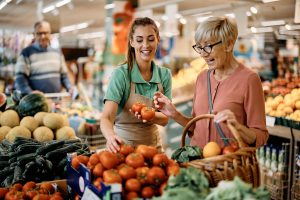 Happy,Senior,Woman,Buying,Tomato,With,Help,Of,Supermarket,Worker